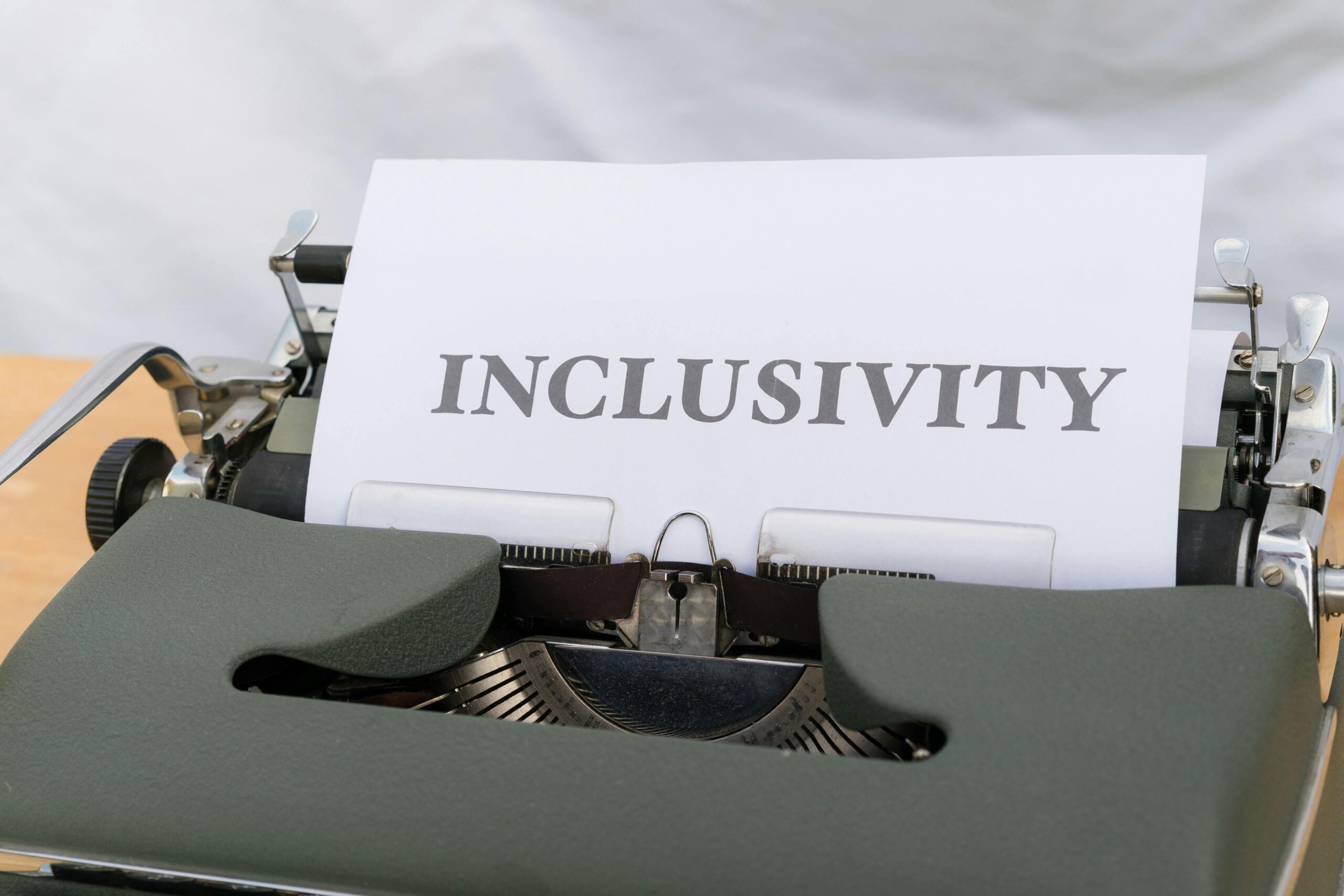 Close-up of a vintage typewriter printing the message 'INCLUSIVITY' on paper.